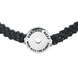 This black macrame bracelet is hand braided using 100% recycled plastic cord. Designed to represent the tires we’re recovering from the Osborne Reef, the tire-shaped bezel is filled with verified 100% crumb rubber from tires that our crews recovered directly from the Osborne Reef.