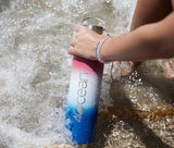 Large Reusable Bottle - Patriotic Ombre in ocean with female model.